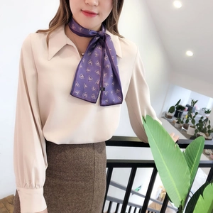 Détail d'un élégant foulard en soie violet à cœurs porté comme une cravate chic