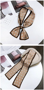Caramel silk scarf with white heart patterns used as a stylish handbag handle wrap