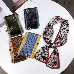 Flat lay of multiple patterned neck scarves with geometric prints on a white display