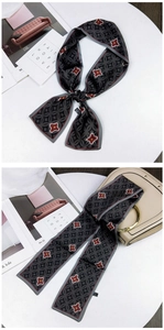 Detail of grey silk scarf with floral geometric pattern used as a handbag accessory