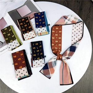 Multiple patterned long skinny silk scarves with cat and polka dot prints on white table