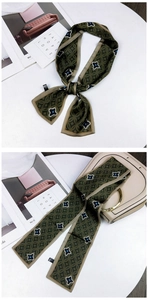 Long silk scarf with geometric pattern tied on a beige handbag for elegant accessory styling