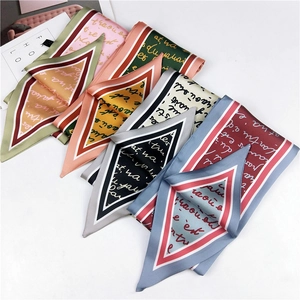 Flat lay of colorful silk scarves with script lettering and geometric V-shaped borders