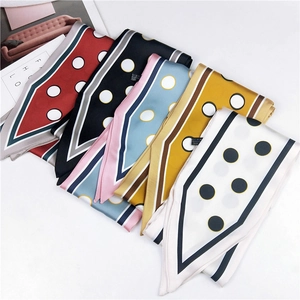 Close-up of assorted polka dot twilly scarves in deep red, black, blue, and yellow