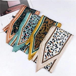 Detail of leopard print silk scarves in four colors with elegant geometric borders