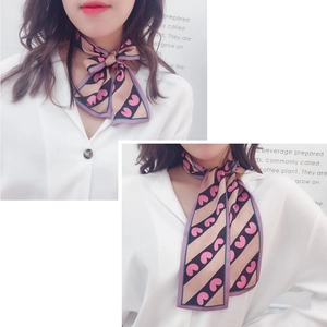 Pink heart and khaki stripe skinny silk scarf tied in a bow on a white shirt