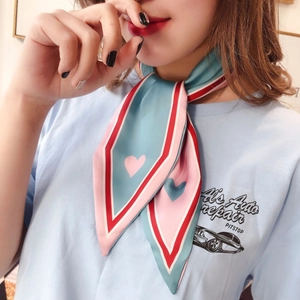 Necklace-style view of a slim mint green and pink twilly scarf with heart patterns