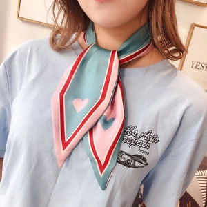Detailed view of striped silk scarf tied as a necktie with heart pattern decoration
