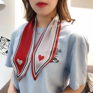 Detail of red, white and blue striped silk twilly scarf with heart print on neck