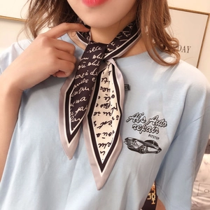 Detail of a chic black and white printed neck scarf tied elegantly on a model neck