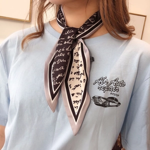 Detail of a vintage-style black and white silk scarf with elegant cursive script patterns