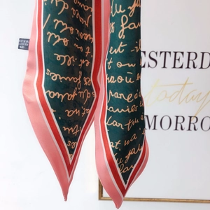Detail of multi-color twilly scarf with 100% polyester fabric texture and care label