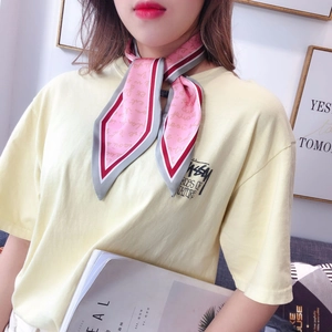 Detailed close-up of a pink silk scarf with vintage script and stylish contrast piping