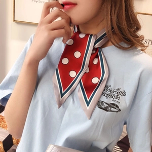 Close-up of a red and white polka dot silk scarf tied as a stylish neck scarf for women