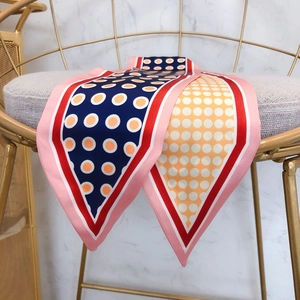 Retro polka dot silk scarf in navy and orange on a modern chair for fashion styling