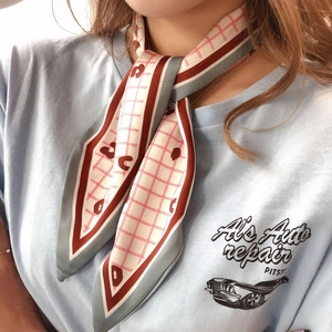 Detail of red and white checkered silk scarf tied on neck with elegant pattern