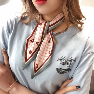 Detail of silk-feel scarf with geometric patterns worn around the neck