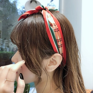 Detail of vintage patchwork silk headband with bow on model in sunlit interior