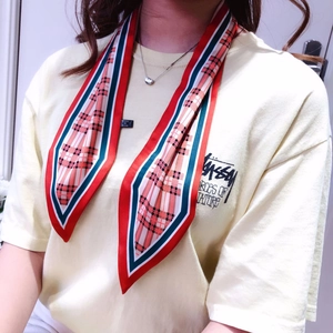 Close-up of British style checkered silk twilly scarf tied on a wrist as a fashion accessory