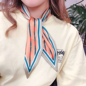 Detail of multi-color striped skinny scarf worn on neck with elegant pointed ends