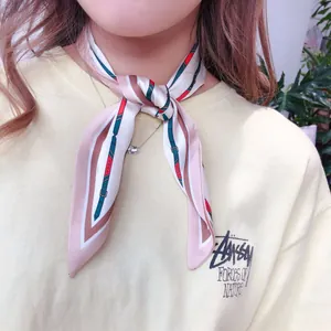 Detail of elegant pointed silk scarf with striped patterns tied around neck
