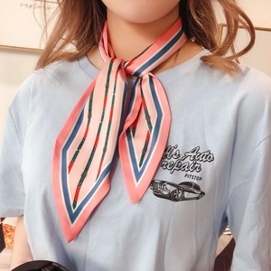 Detail of pink and blue striped silk scarf tied as a neck ribbon for women
