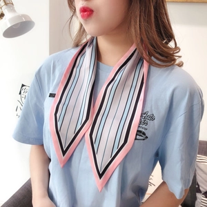 Detail view of a colorful striped narrow silk scarf worn as a stylish neck ribbon accessory