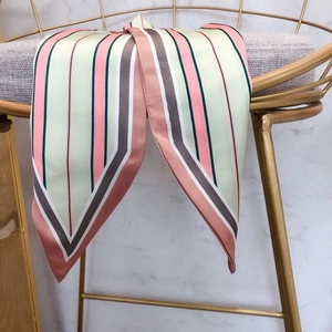 Close-up of a striped silk twilly scarf hanging on a gold chair with soft silk texture