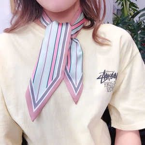 Close-up of a striped silk twilly scarf tied around the neck showing glossy pink and green colors