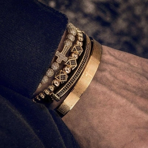 Detail of men's vintage gold stackable bracelet set featuring cross and scripture engraving
