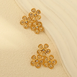 Dettaglio di orecchini a foglia placcati oro 18k con design a fiori di zirconi