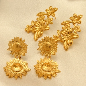 Orecchini a fiori in acciaio al titanio dorato su elegante tessuto di raso champagne