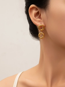 Close-up of elegant gold geometric double circle drop earrings on female model