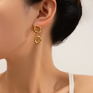 Minimalist double circle golden stainless steel drop earrings worn by a model