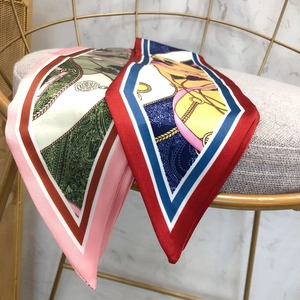 Detailed view of silk-like scarves featuring equestrian and nautical prints with contrast hems
