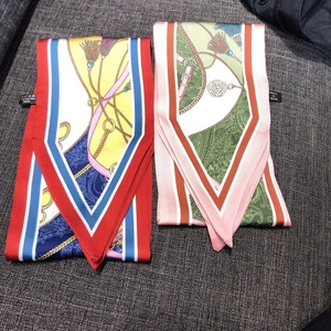Detail of two narrow satin scarves with vintage gold chains and paisley flower patterns