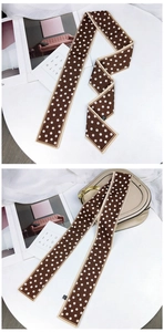 Gros plan d'un foulard étroit marron à pois utilisé comme accessoire de sac