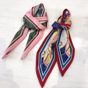 Flat lay of colorful paisley print silk scarves on a premium white marble background