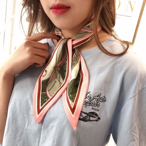 Detailed view of elegant printed silk scarf tied as a stylish wrist accessory