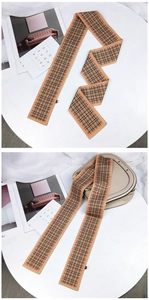 Détail d'un foulard étroit à carreaux noué sur un sac de selle blanc avec élégance