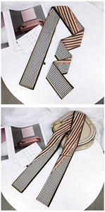 Détail d'un foulard étroit à rayures utilisé comme décoration élégante sur une poignée de sac