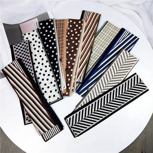 Divers foulards étroits en soie à pois et motifs géométriques sur décor blanc élégant