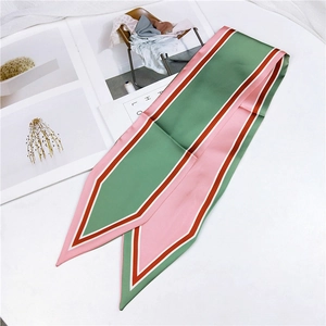 Detail of satin twilly scarf with pink and green stripes draped on a white surface