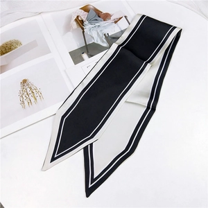Close-up of a black and white striped satin twilly scarf with elegant pointed ends