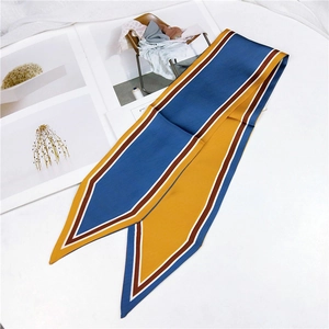 Macro detail of silk twilly scarf with blue and yellow geometric patterns and sharp edges