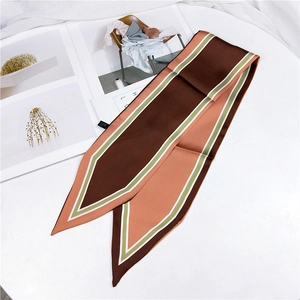 Macro detail of geometric color block twilly silk scarf with pointed ends and care label