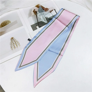 Detailed flat lay of pink and blue silk twilly scarf on a magazine background