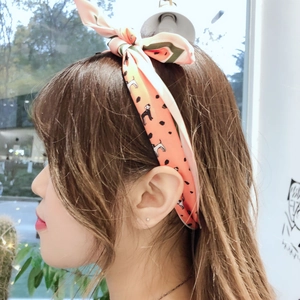 Detail of light peach hair ribbon with black puppy prints and bow on model profile