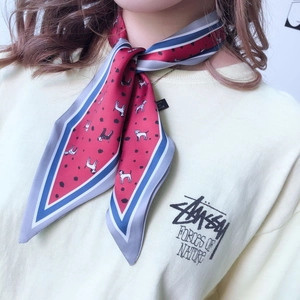 Close-up of red silk scarf featuring black and white puppy print and polka dot pattern