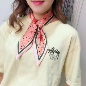Detailed view of coral pink polka dot silk scarf tied around neck with cute puppy print